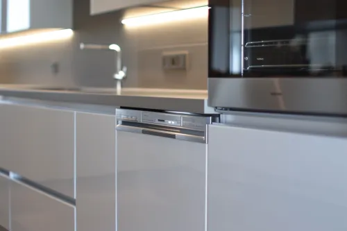 Installation professionnelle des raccordements de plomberie dans une cuisine moderne avec positionnement stratégique des points d'eau